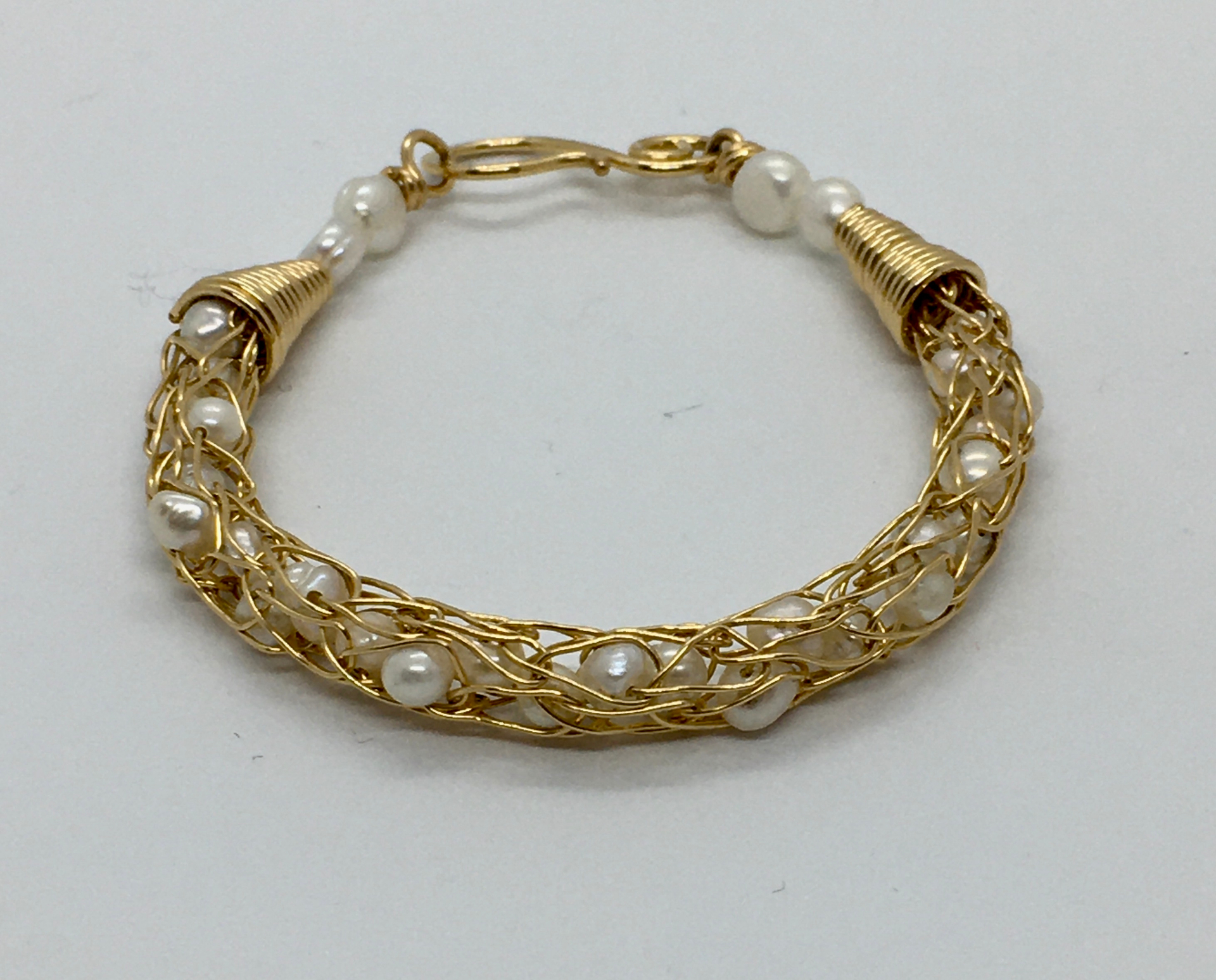 photo of a bracelet made of gold wire and pearls
